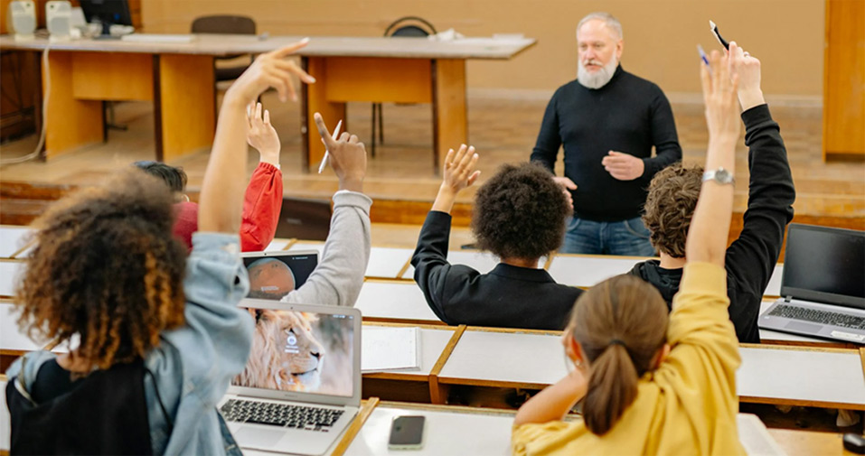 Students raising hands in a classroom | Pexels | Photo by Yan Krukau